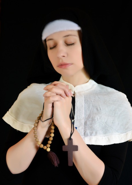 Nun in habit with rosary and cross.