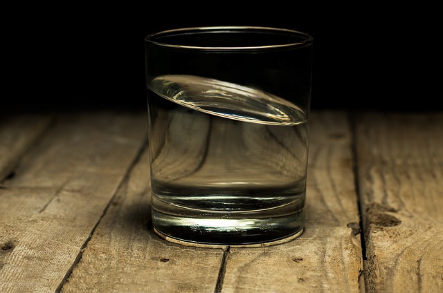 Glass of water on wooden table.