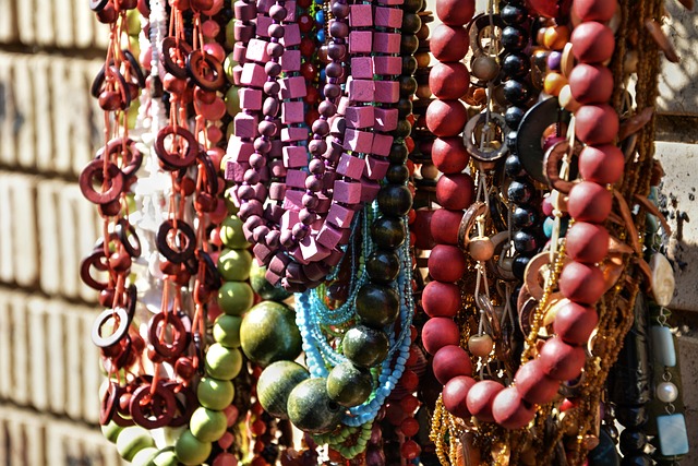 Colorful necklaces hanging on brick wall.