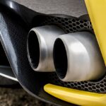 The exhaust pipes of a bright yellow sports car.