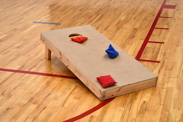 Cornhole board and bags on wooden floor.