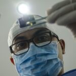 Surgeon holding a light in hand during surgery.