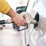 A person fueling up their car at a gas station.