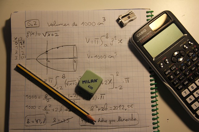 Calculator, pencil, and notebook on table.