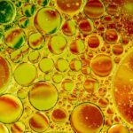 Oil bubbles in water with orange and yellow swirls