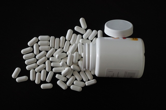 A bottle of pills resting on a sleek black surface, showcasing its label and contents against a dark backdrop.