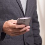 Businessman in suit holding smartphone.