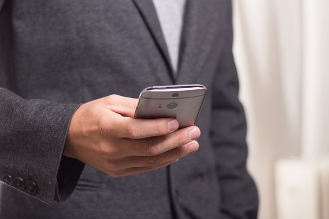 Businessman in suit holding smartphone.