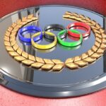 Olympic rings on metal plate against red background.