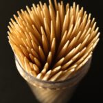 Container filled with wooden toothpicks.