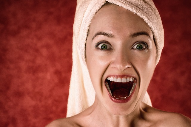 A woman with a towel on her head, mouth open.